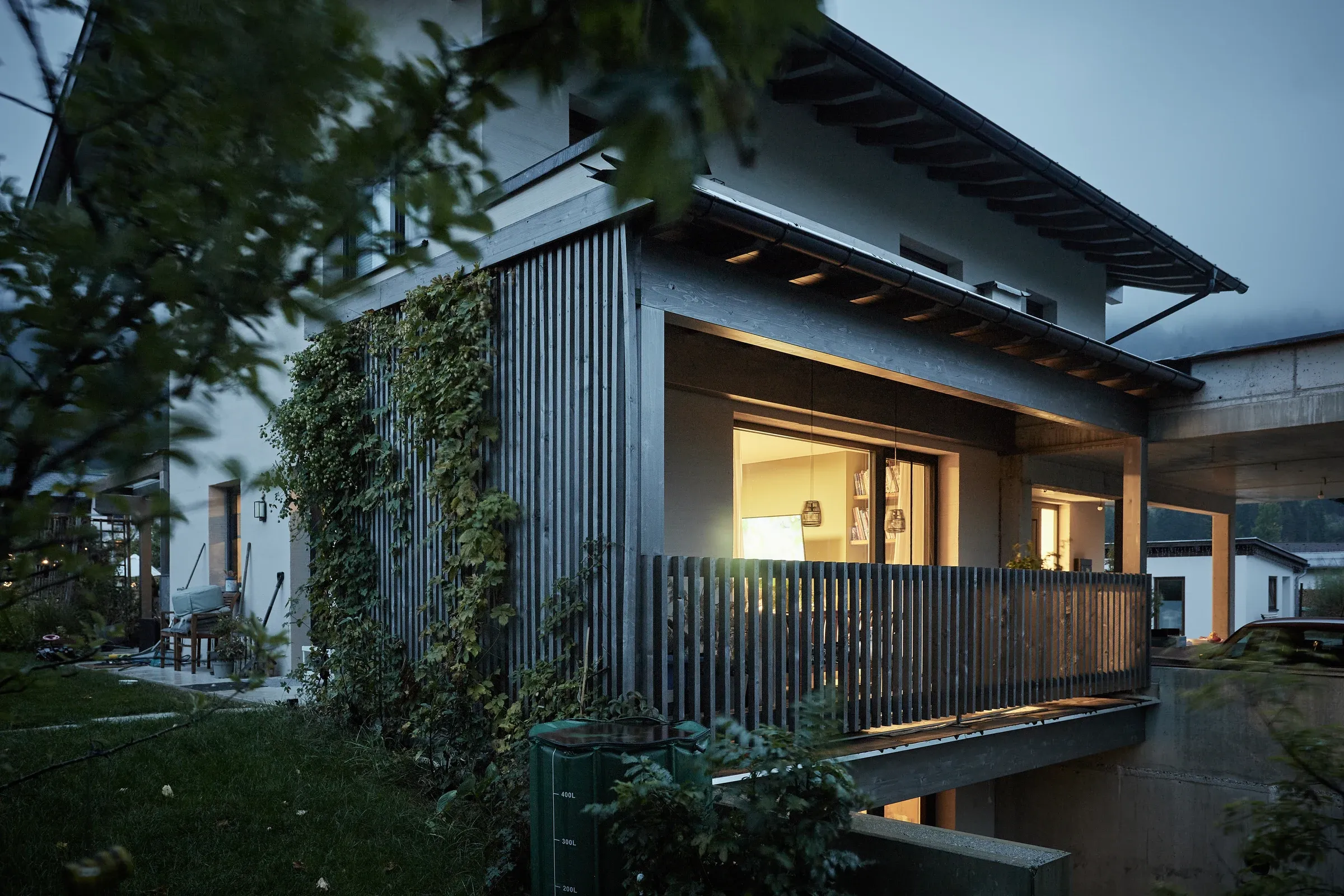 Das Haus am Abend, Holzfassade und Balkon, innen Licht
