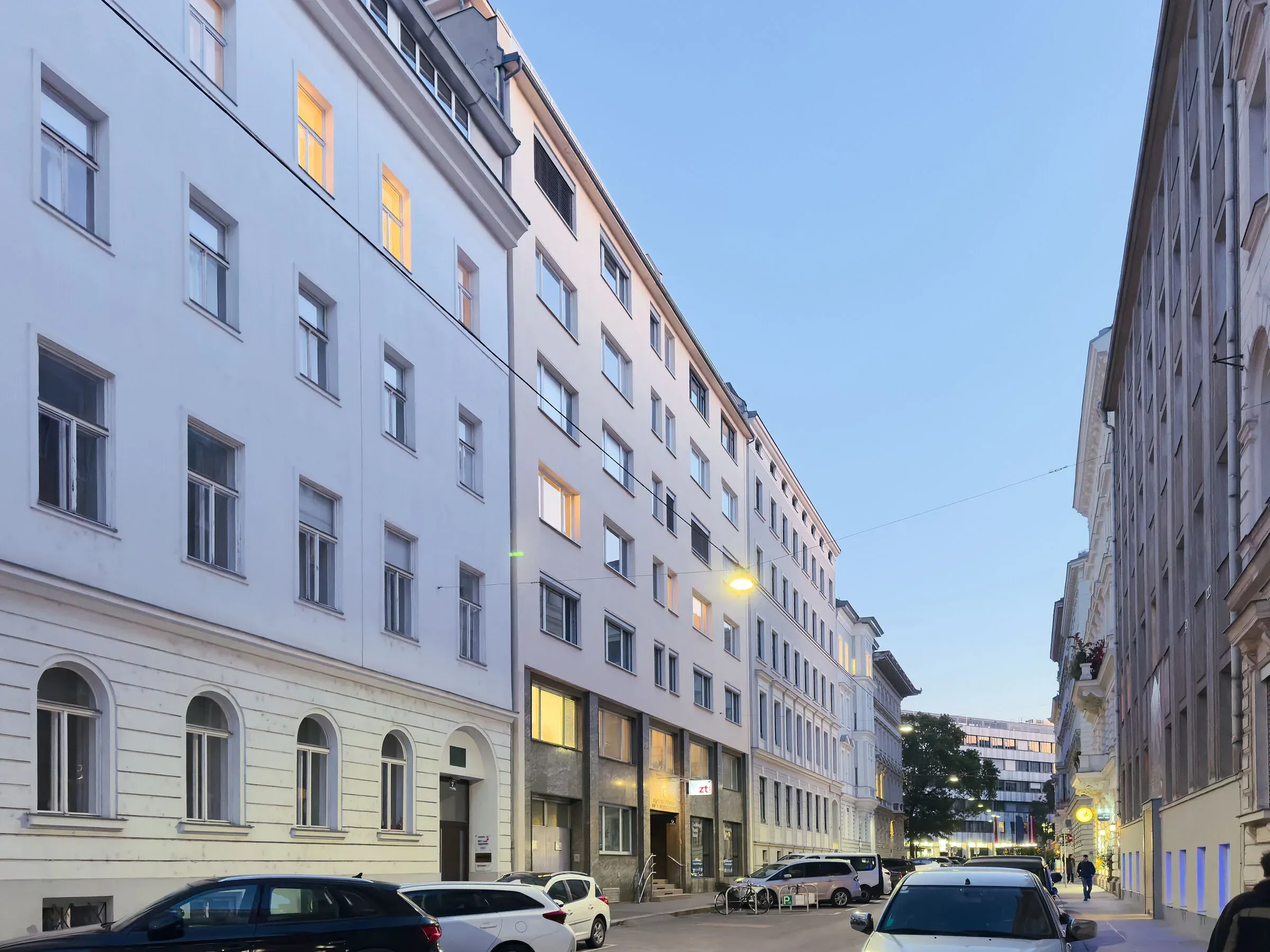 Straße in Wien mit dem Bürohaus des Wettbewerbs