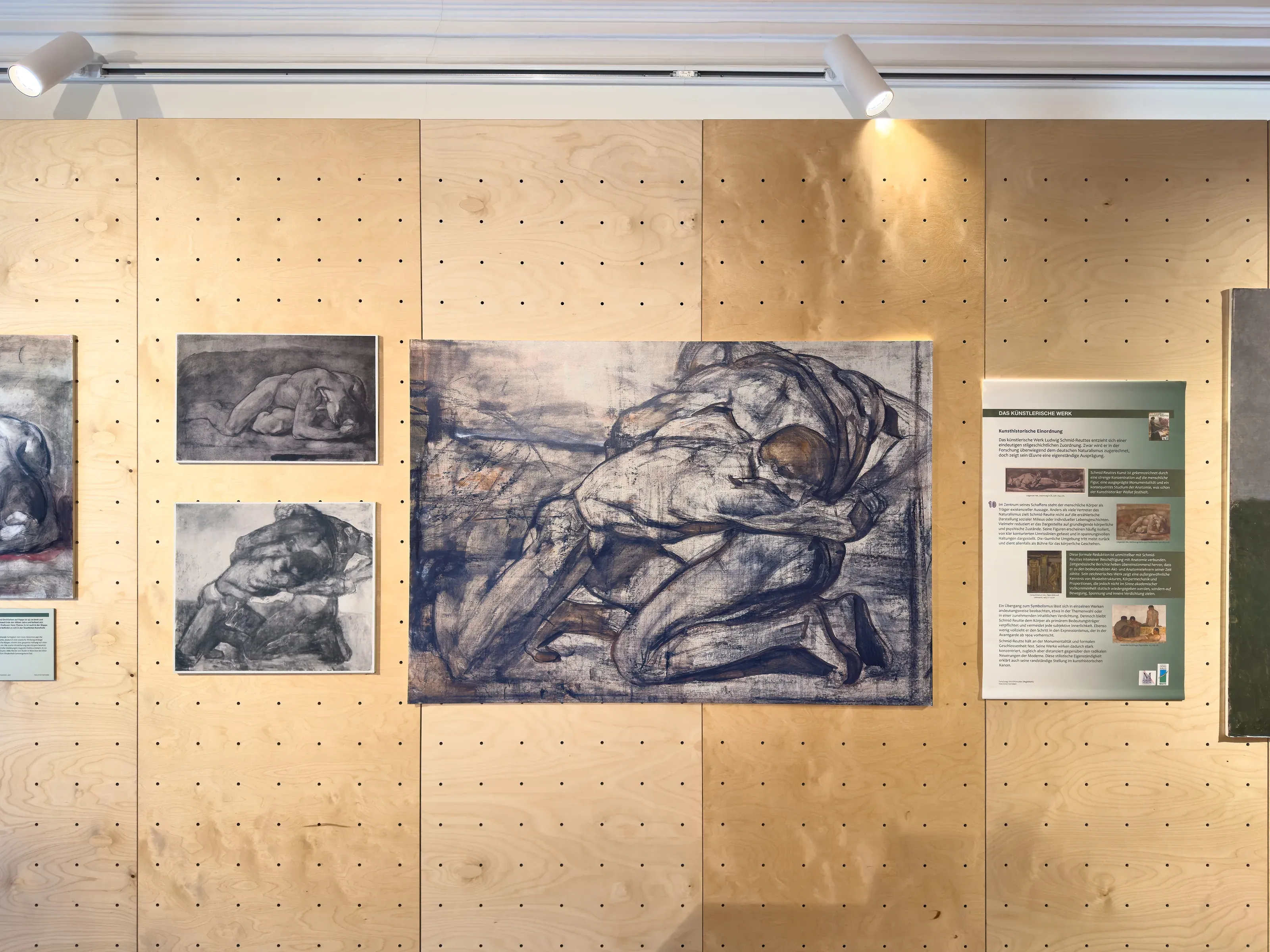 Dieselbe Lochwand mit Zeichnungen und Texttafel der Ausstellung zu Ludwig Schmid-Reutte